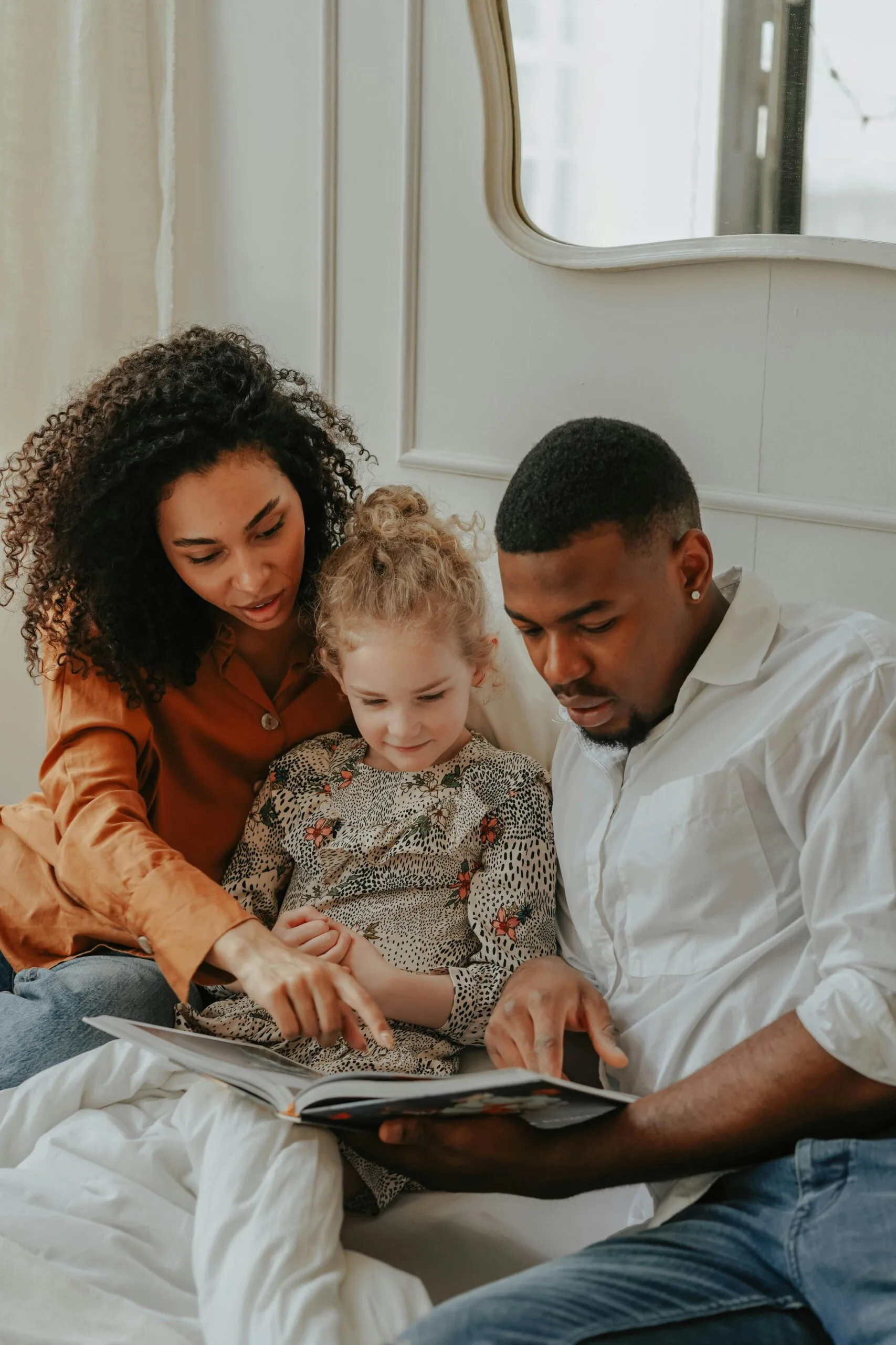 couple reading a book to a child