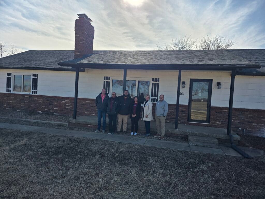 Members of the leadership team stand in front of the new Tyler House location servicing foster children