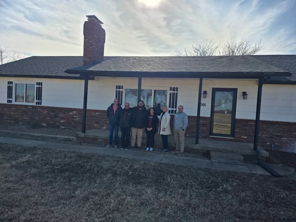Members of the leadership team stand in front of the new Tyler House location servicing foster children