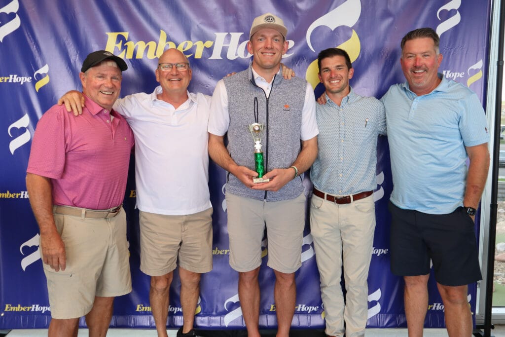 Ron Baker poses with his team and his trophy
