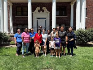 Susan Peters and a group of people stand in front of Libbey Hall in Newton