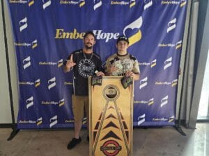 The tournament winners posing with a cornhole board